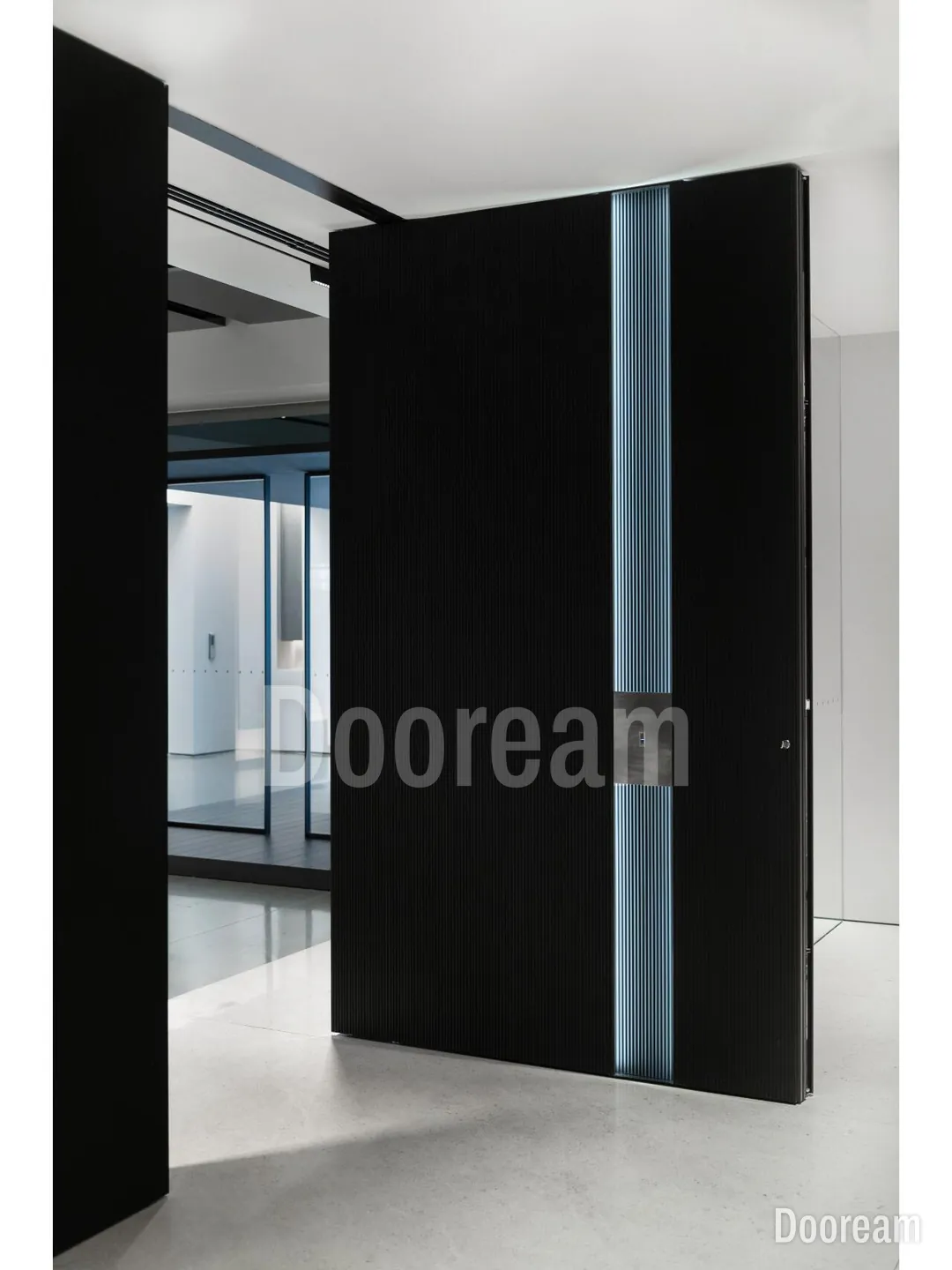 A black fluted aluminium pivot door with a full-height light strip in the showroom