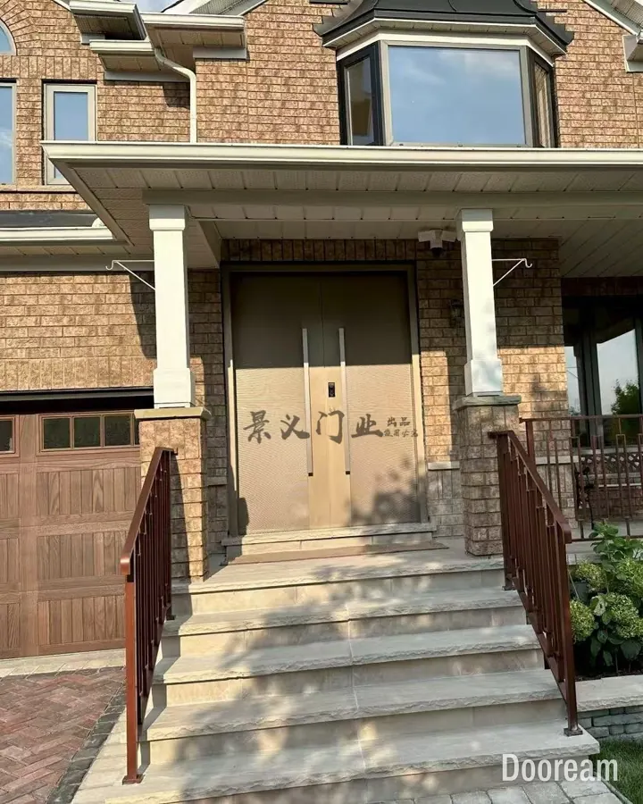 Champagne-gold double door with full-height pull handles on a brick house porch, installed at a client's home