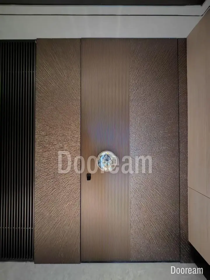 Bronze textured door with a round, faceted handle, installed