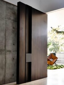 Custom Modern Architectural Aluminum Entrance Door with Wood Grain Finish Sidelight and Long Black Handle Installed at a Luxury Home Entrance.