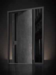Bespoke industrial metal pivot door with hammered vertical texture and oversized gold bar handle.