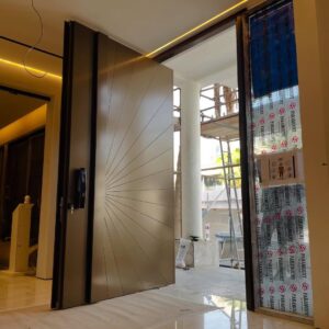 Luxury champagne gold pivot door with precision-etched sunburst linear patterns and integrated black smart handle.