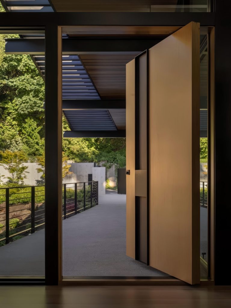 Pale warm door with black vertical recess and glazed surround