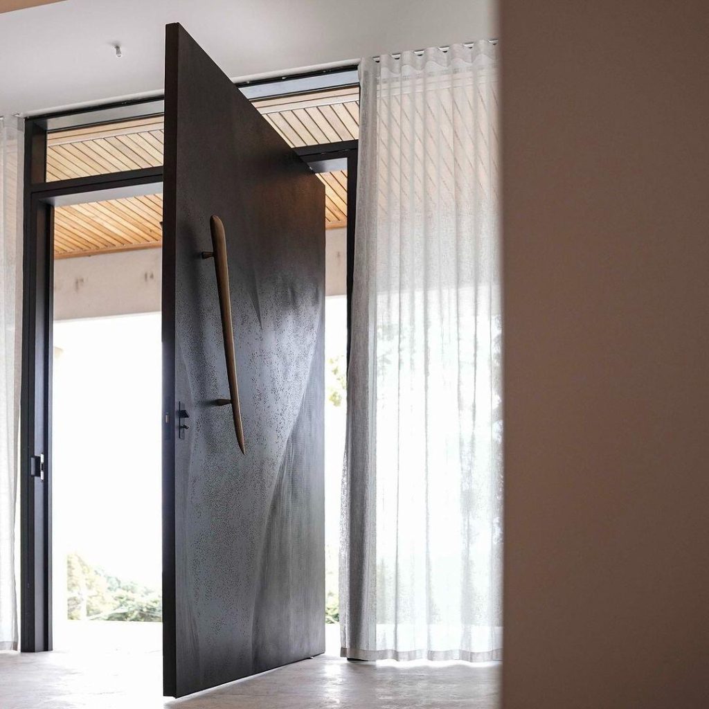 Dark textured door with irregular warm-brown pull